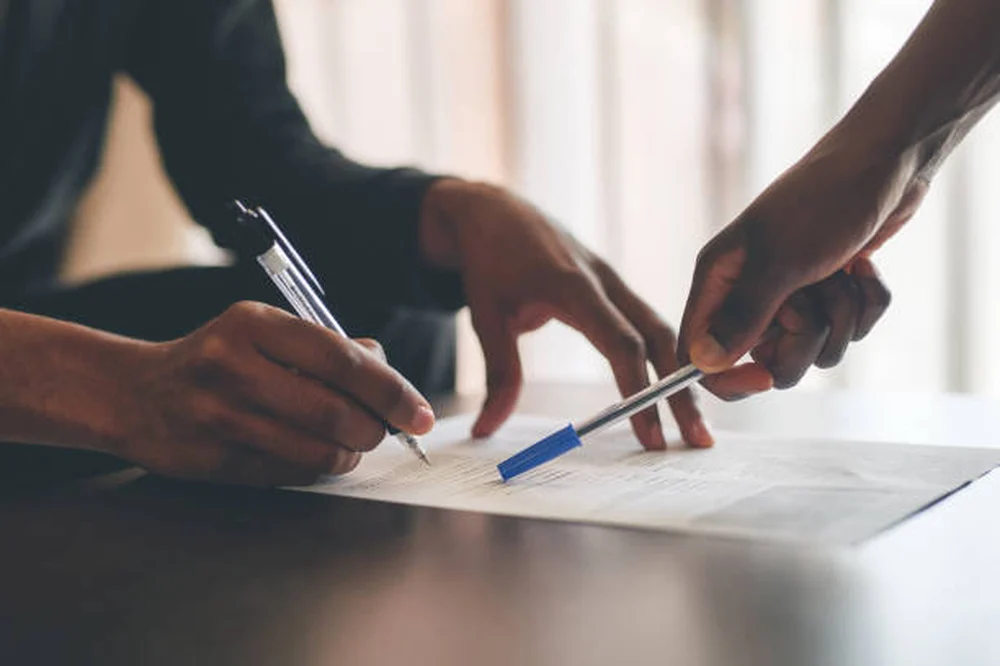 A JPW advisor reviewing and signing benefit paperwork with a client